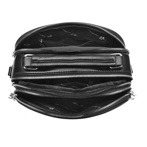 Macro view of black pebbled leather handbag featuring triple zipper compartments and silver hardware