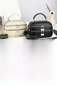 Detailed macro view of the triple zipper design and leather texture of the BOX SERIES bag