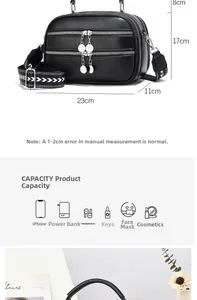 Detail view of black pebble leather crossbody bag with three zip pockets and wide strap