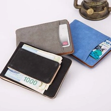 Flat lay of black, grey and blue leather card wallets showing card slots and cash clips