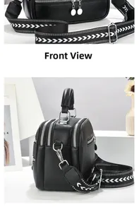 Detail of black lychee leather crossbody bag with patterned wide strap and silver hardware