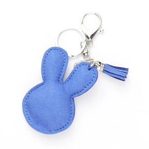 Detail of blue rabbit keychain with tassel and high-quality stitching on white background
