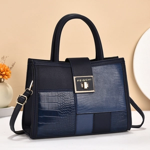 Deep blue multi-texture patchwork handbag with gold rotary lock and crossbody strap