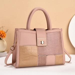 Chic pink and beige patchwork handbag with crocodile texture and gold hardware detail