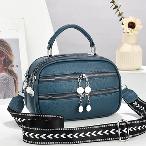 Navy blue pebble leather handbag with triple zippers and geometric woven strap