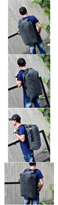Outdoor male model shot showing high-capacity grey canvas travel backpack from multiple angles