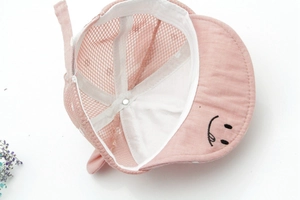 Detail view of pink baby baseball cap with smile embroidery and breathable mesh