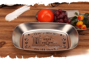 Macro shot of oval metal tray with HOME IS WHERE THE HEART IS vintage house pattern