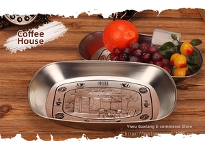 Macro view of vintage boat-shaped tin tray with detailed coffee house embossed pattern