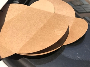 Flat kraft paper envelope with pre-scored fold lines showing texture and structure