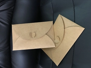 Detail of 300g kraft paper envelopes featuring a unique heart-shaped closure design