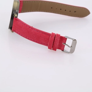 Close-up of red fabric texture watch strap with silver buckle and brown inner lining