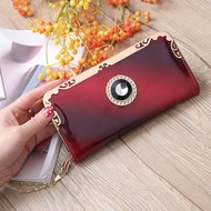 Close-up of wine red gradient clutch bag with crystal gemstone and gold metal frame