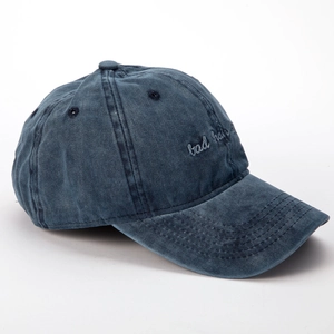 Detalle del bordado bad hair day en la gorra de béisbol de mezclilla azul lavado