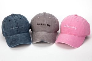 Detalle de gorras de béisbol vintage lavadas con bordado bad hair day en tres colores