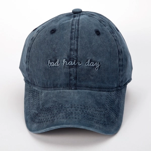 Detalle del bordado 'bad hair day' en la gorra de béisbol de mezclilla azul lavado