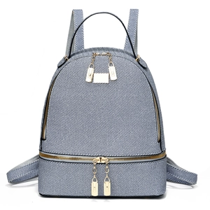 Vista frontale di uno zaino in twill azzurro con hardware dorato e manico superiore