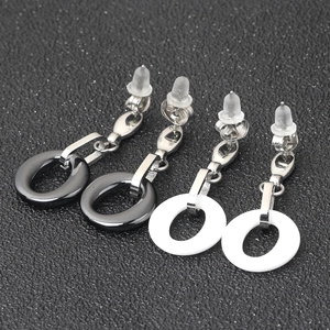 Detailed view of black and white ceramic round earrings with silver stainless steel studs