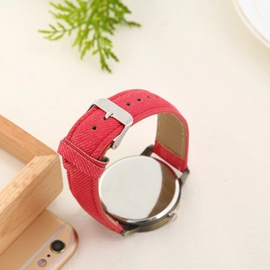 Close-up of the red denim fabric strap and silver metal buckle on a quartz wrist watch