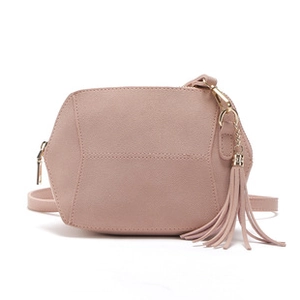 Detail of pink faux suede geometric handbag with golden zipper and fringe tassel decor