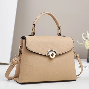 Detailed close-up of apricot lychee pattern leather handbag with golden semicircular lock