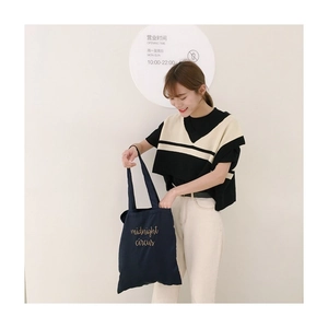 Detail view of navy canvas tote bag with midnight circus embroidery and sturdy handles