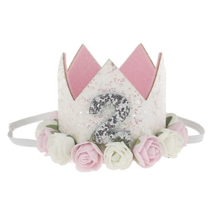Detailed close-up of a white and pink floral birthday crown for a two-year-old toddler
