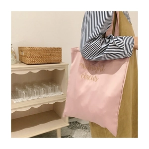 Detailed embroidery of midnight circus on a pink satin shoulder tote bag for women