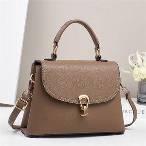 Sac à main élégant en cuir marron avec garnitures dorées et détail de pompon chic