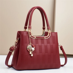 Burgundy faux leather handbag for women featuring textured weave and shell metal charm