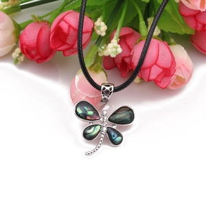 Detailed close-up of a dragonfly pendant with iridescent shell wings and white zircon stones