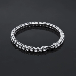 Macro detail of silver tennis bracelet with sparkling round clear stones and fold-over clasp
