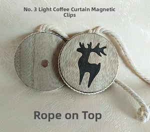 Detail of wooden magnetic curtain tieback with reindeer print and woven rope in coffee