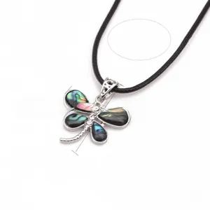 Detail view of dragonfly pendant featuring iridescent abalone shell wings and crystal accents