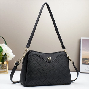Close-up of black litchi grain leather crossbody bag with floral quilting and BB logo