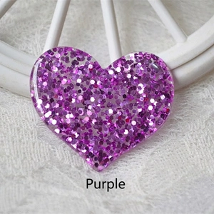 Macro detail of heart-shaped purple glitter resin accessory for DIY hair clips