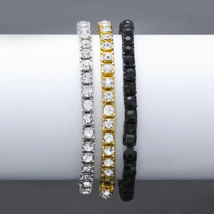 Detailed view of silver, gold, and black tennis bracelets on a cylinder display