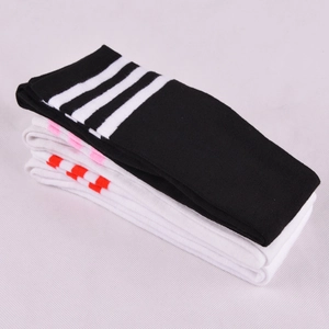 Flat lay view of stacked knee-high dance socks featuring classic three-stripe knit patterns