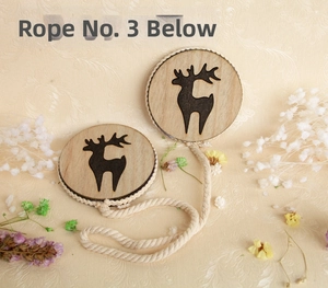 Detail view of two circular wooden reindeer pendants with rustic braided rope ties