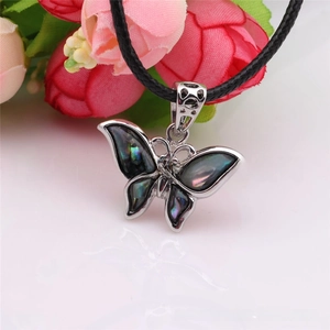 Macro shot of butterfly pendant necklace with iridescent abalone shell wings on silver base