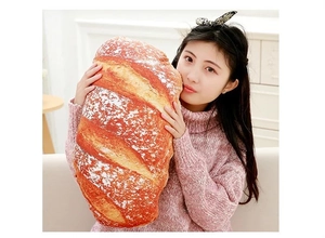 Realistic large French baguette plush pillow held by a woman in a cozy home setting