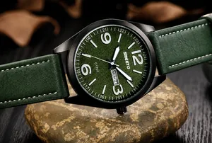 Primer plano de esfera verde texturizada y calendario en reloj deportivo militar negro