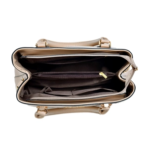 Macro view of interior compartments and gold zipper on a beige leather handbag