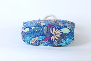 Detailed side view of blue canvas tote bag with leaf pattern and thick hemp rope handle