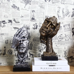 Artistic gold and silver Silence is Golden resin sculptures on books with retro background