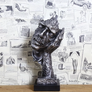 Artistic detail of retro resin silence is golden sculpture with vintage newspaper background