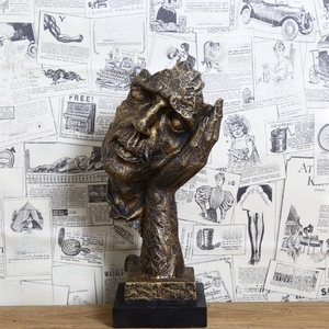 Macro detail of abstract character sculpture in gold and black on retro background