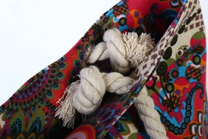 Detail of bohemian floral canvas tote with white cotton rope handles and metal eyelets