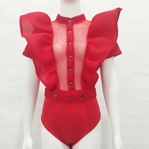 Detail of red bodysuit featuring ruffled shoulders, mesh panel, and metal buttons