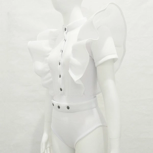 Detail of white ruffled bodysuit featuring stand collar and silver metallic snap buttons